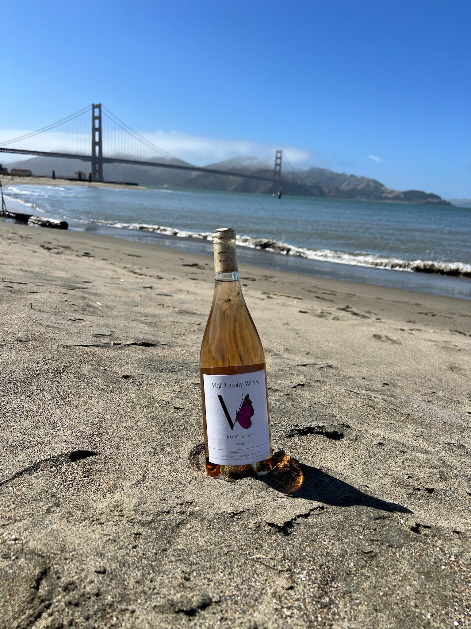 Bottle of wine on a beach with the San Francisco Golden Gate Bridge in the background